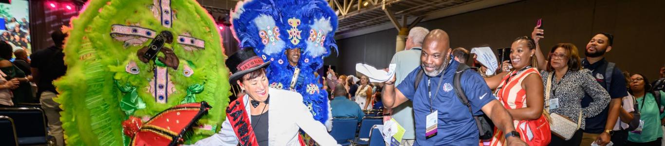 Attendees dance and join the band as they exit the keynote session of the 2025 confernece