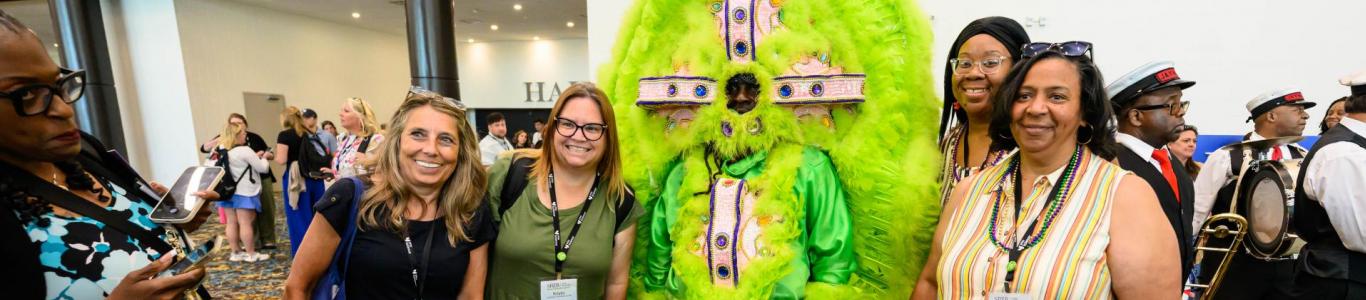 2025 attendees pose with a Mardi Gras Indian