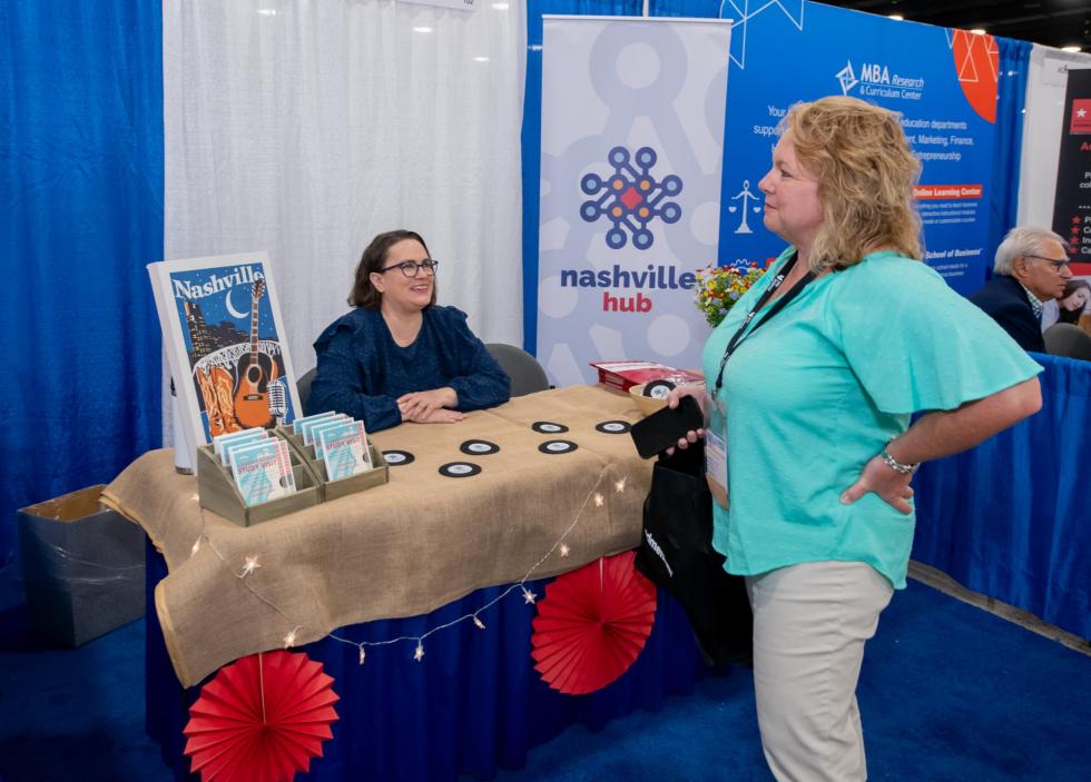 Attendee talks to sponsor in exhibit booth